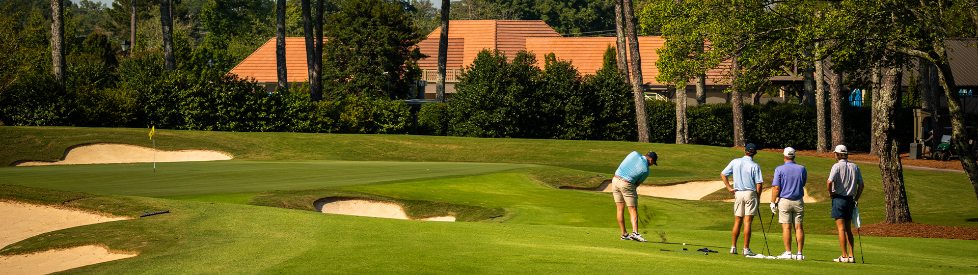 A picture of a beautiful golf course with several golfers enjoying a game.