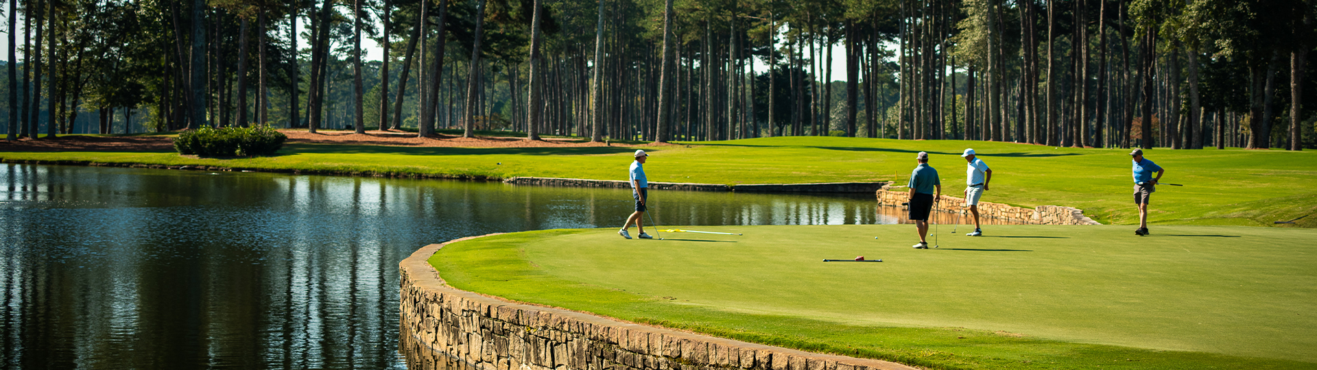 A picture of a beautiful golf course with several golfers enjoying a game.