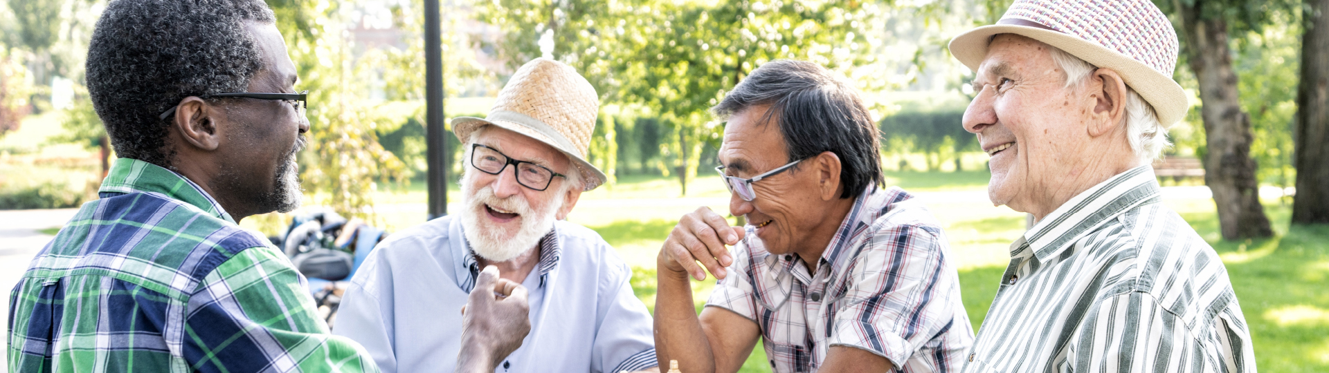 Four seniors sit around a table, conversing and having a good time at their senior living community.