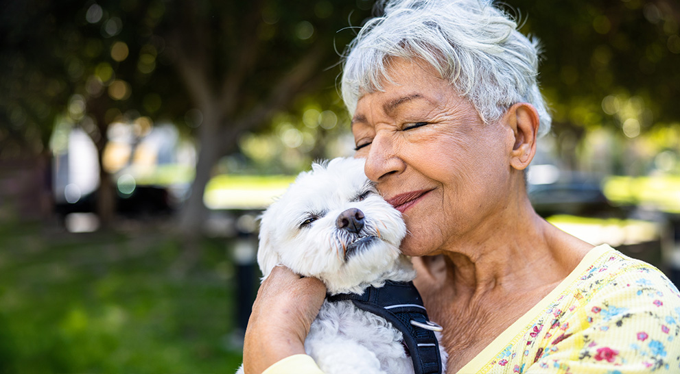 A senior and a small dog at a senior living community in georgia.